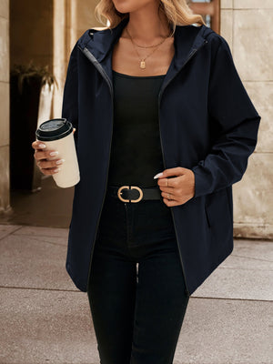 Navy zip-through hooded jacket with a relaxed fit, worn open over a black tank top.
