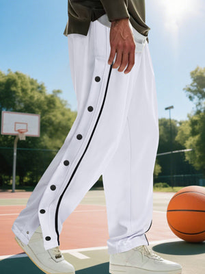 White track pants with black snap buttons and side stripe detail.