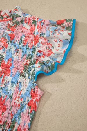 Vibrant floral maxi dress with smocked bodice, flutter sleeves, and blue trim.
