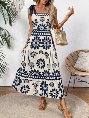 Charming floral tie-shoulder midi dress in dark blue and cream with a-line cut and scalloped hem.