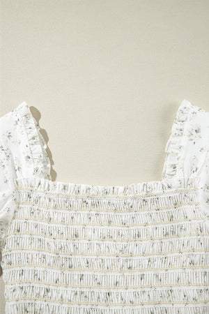 White floral smocked bodice jumpsuit with ruffled square neckline and short sleeves.
