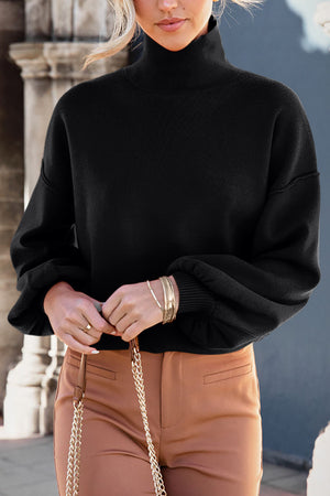 Black knit sweater with mock neck and balloon sleeves.
