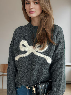 Dark gray acrylic knit sweater with white bow intarsia design and mock neckline.