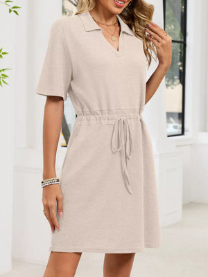 Textured polo dress in apricot with short sleeves, V-neck, and adjustable drawstring waist.