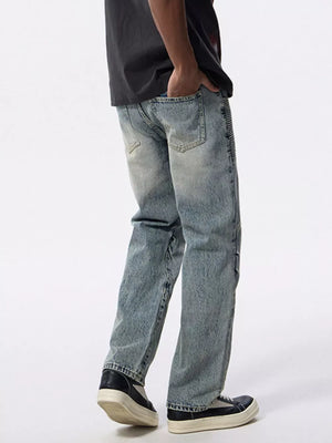 Men's light wash denim jeans with moto-inspired detailing on the side and a wide-leg fit.