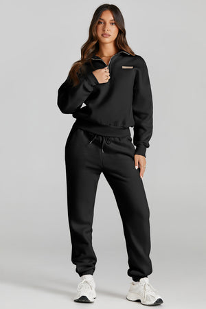 Black quarter-zip sweatshirt and jogger set with drawstring waist and a small logo patch.
