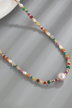 Multicolor beaded necklace with freshwater pearls and gemstones on a gold chain.