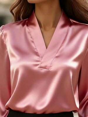 Elegant pink satin V-neck blouse with gathered sleeves.