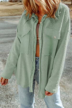 Sage green textured shacket with raw edge detailing and buttoned pockets.