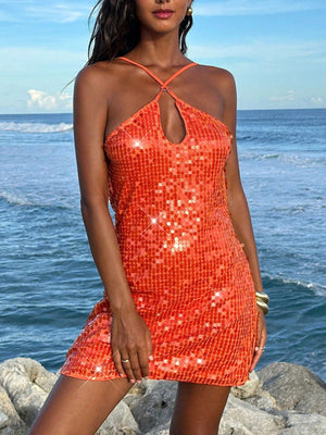 Orange sequin backless mini dress with halter neckline and keyhole cutout.
