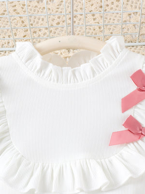 White ribbed toddler top with ruffled neckline and pink bows