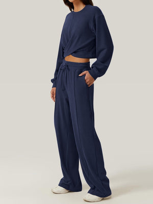 Navy knit lounge set with cross-front crop top and wide-leg drawstring pants.