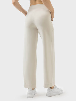 Cream wide-leg drawstring active trousers with pockets, styled with white sneakers.