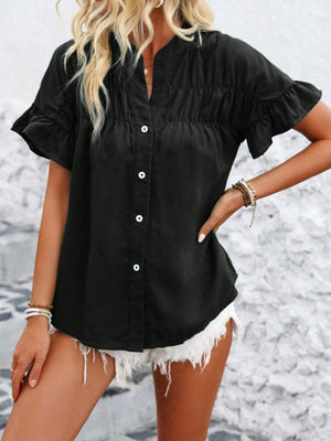 Black button-up blouse with gathered yoke and ruffle sleeves.