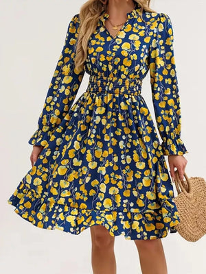Navy floral smocked dress with yellow flowers, ruffled hem, and long sleeves.