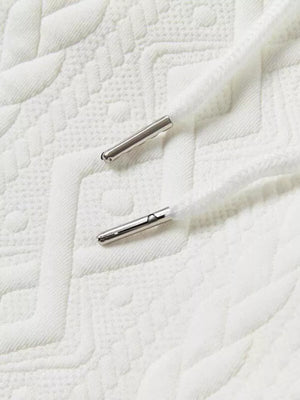 White knit shorts with textured pattern and silver-tipped drawstring.