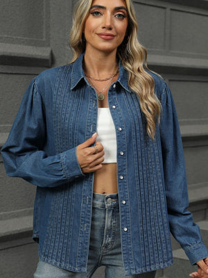 Navy denim shirt with puffed sleeves, pleats, and buttons.