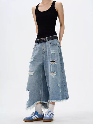 Distressed light wash denim wide-leg jeans with raw hem and ripped details.