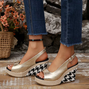 Gold open-toe wedge sandals with decorative buckle and houndstooth pattern wedge.