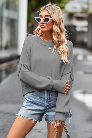 Gray ribbed knit batwing sweater with crew neck and cropped length.
