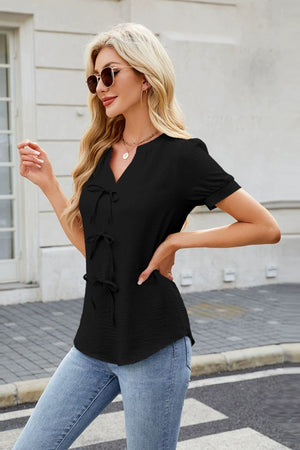 Black textured blouse with tie-front detail and short sleeves.