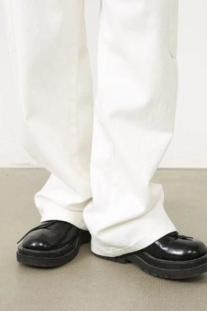 White 100% cotton pleated cargo pants with a wide leg cut.