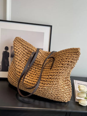 Natural woven straw shoulder bag in khaki with dark brown leather straps.