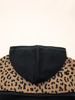 Leopard print hoodie with black hood and textured fabric detail.