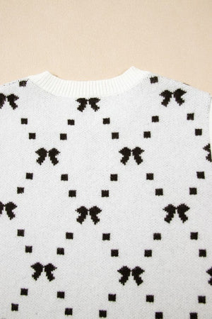 White knit tank sweater with black diamond bow pattern and ribbed neckline.