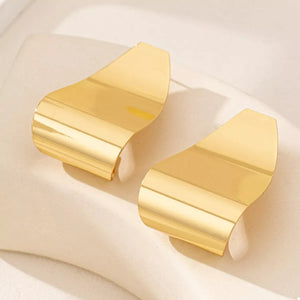 Golden alloy geometric earrings with a curved, wave-like design.