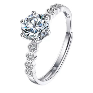 Silver ring with a large round moissanite and honeycomb band with small stones.
