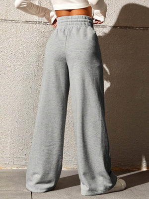 Gray sweatpants with drawstring waist and wide legs.