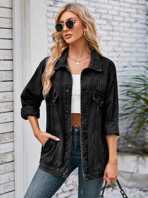 Black oversized denim trucker jacket with rolled sleeves and buttoned pockets.