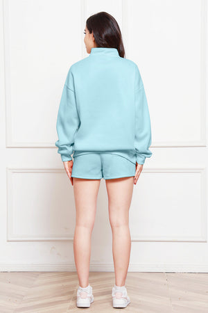 Light Blue quarter-zip loungewear set with shorts and a mock neck sweatshirt.
