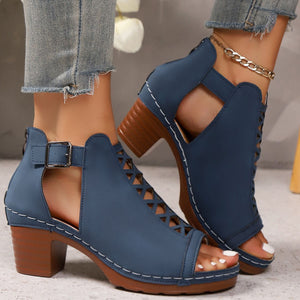 Navy blue criss-cross cut-out block heel sandals with ankle strap and buckle detail.