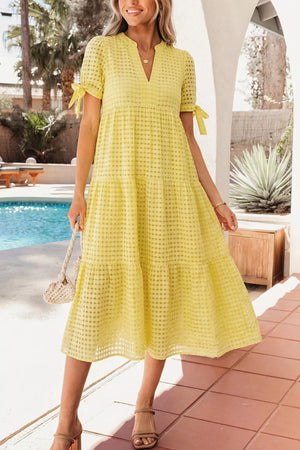 Yellow gingham midi dress with V-neck, short sleeves with bow ties, and tiered skirt.