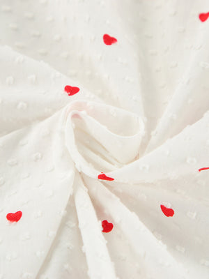 White cotton pajama fabric with red heart print and textured dots