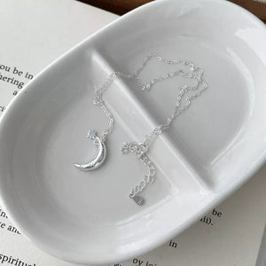 Sterling silver necklace with crescent moon and star charms, adjustable chain