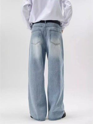 Men's wide-leg wash denim jeans in light blue with a relaxed fit.