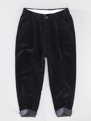 Black corduroy pleated pants with elastic waistband and cuffed hem
