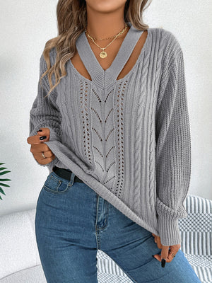 Gray cable knit sweater with cutout neckline and leaf pattern detail.