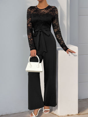 Black lace bodice wide-leg jumpsuit with tie waist and long sleeves.