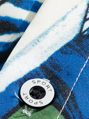 Tropical print oversized button-up shirt in blue, white, and green cotton with a white button detail.