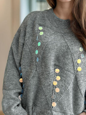 Gray knit sweater with geometric sequin embellishments and a mock neck.