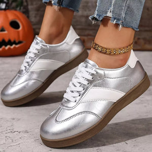 Silver patent leather lace-up sneakers with white accents and brown soles