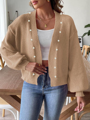 Tan knit cardigan with bubble sleeves and pearl buttons, open front.
