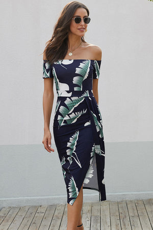 Off-shoulder midi dress in navy with white and green leaf print, featuring a side slit.