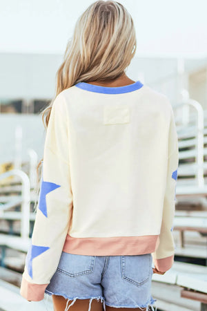 Ivory cotton sweatshirt with blue star sleeves and pink hem.