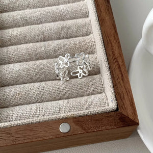 Sterling silver open ring with delicate floral motifs.