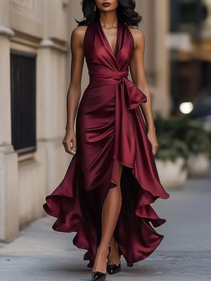 Wine red satin high-low ruffled maxi dress with cinched waist and bow detail.